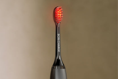 Black electric toothbrush head with red bristles on a beige background